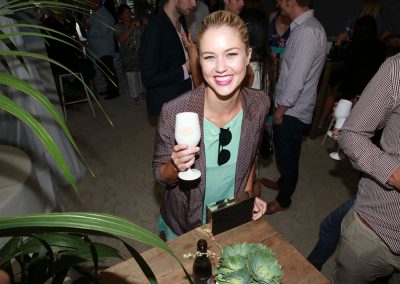 Guest smiling holding drink Brown Brothers Summer of Prosecco Pop-Up Beach Bar
