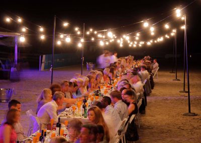Guests sitting at table outside night time Cable Beach Broome Polo Tournament
