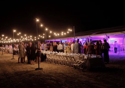 Guests standing talking outside night time Cable Beach Broome Polo Tournament