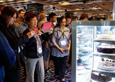 Guests admiring taking photos of cakes Cheesecake Shop Franchise Conference