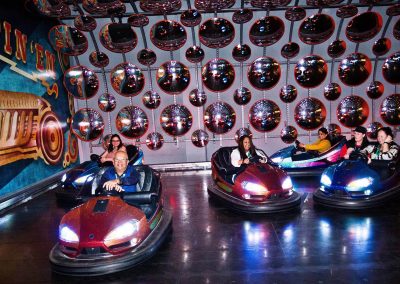 Guests having fun driving dodgem cars at the Cheesecake Shop Franchise Conference