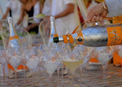 Champagn bottle pouring in glass Clicquot Beach House