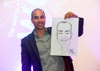 Guest smiling holding caricature drawing Credit Union Australia National Business Strategy