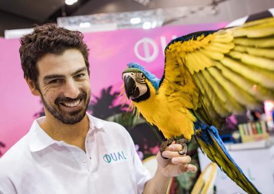 Smiling man holding parrot Dual Australia Exhibition Stand - Miami Poolside