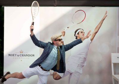 Guest copying Roger Federer serve image in background at Moet et Chandon event