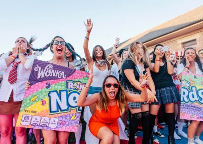 Groupf of women laughing holding Wonka Rainbow Nerds signs Google Summer Party event