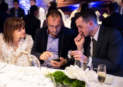 3 guests looking at phone at Gregory Jewellers & Breitling VIP client dinner