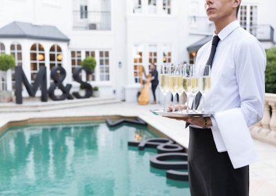 Waiter holding tray drinks outside pool Marks & Spencer Australian Online Store launch