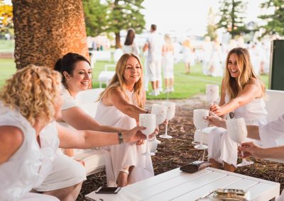 Female guests holding goblets toasting Moet Dinner en Blanc National Sponsorship Activation