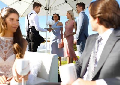 Waiter serving guests at Moet et Chandon Lawn at Melbourne Racing Club