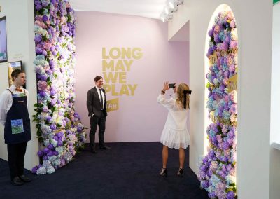 Guest taking photos in front of the Tabcorp floral wall